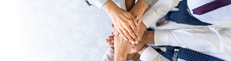 Close up top view of young business people putting their hands together. Stack of hands. Unity and teamwork concept.